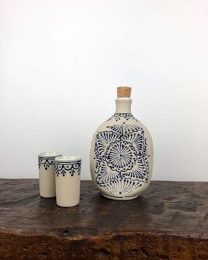 Ceramic decanter set with two shot glasses on timber bench